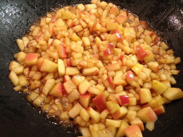 然後用小火拌炒約 15-20 分鐘至蘋果丁軟化，糖汁略微收乾。