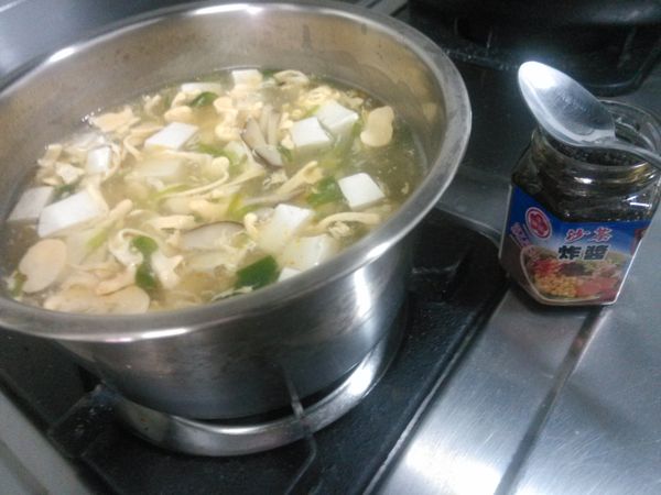 然後加入1湯匙的牛頭牌沙茶炸醬與少許白胡椒粉，用筷子輕輕攪拌均勻。