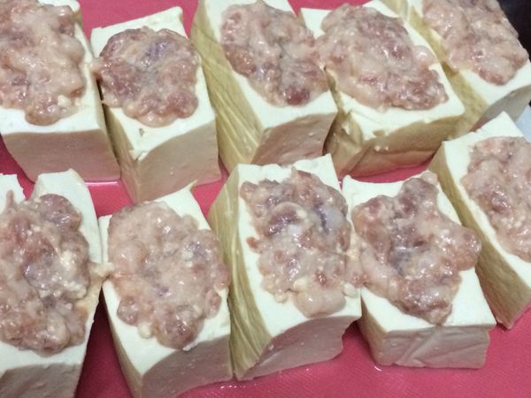 將肉餡填入豆腐凹槽裡，留一些鋪在豆腐面