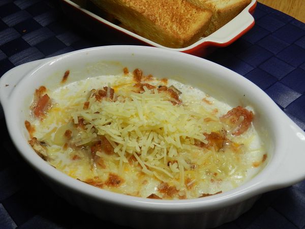 做好的蘑菇培根上，再撒上帕米森起司絲