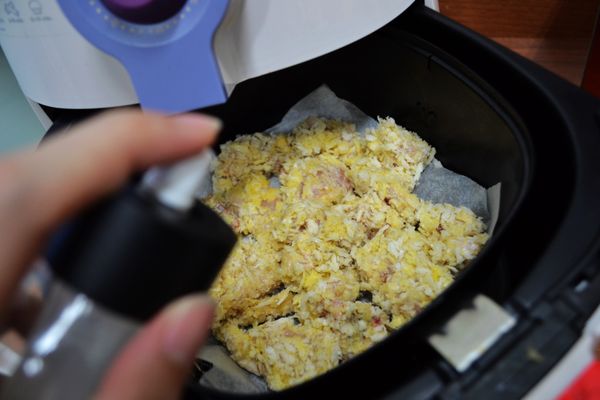 氣炸鍋鋪上烘焙紙，再將雞塊放入，均勻的噴上少許油。
