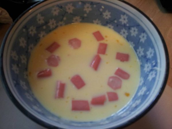 將雞蛋、熱狗切小段、牛奶攪拌在一起