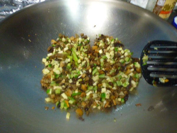 放下黑木耳、筊白筍丁炒香後，加入菜埔小菜略炒再加入白飯快速翻炒---粒粒分明後，加入高麗菜丁、小黃瓜丁翻炒數下後，鍋邊淋點米酒及蔥花快炒，增添香氣。