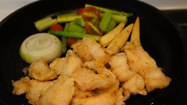 配菜炒至五分熟，將炸魚撈起瀝乾油並放上鑄鐵鍋