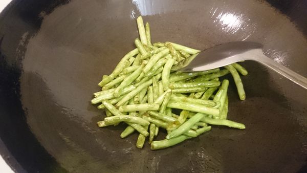 四季豆洗淨掐頭去尾折段, 熱鍋後放二大匙油放入四季豆煸炒至表皮皺皺的撈起備用