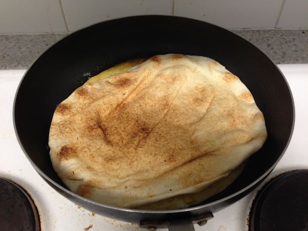 將蛋液倒入油鍋加熱，等稍微凝固後鋪上土耳其餅，讓蛋液附著在餅上