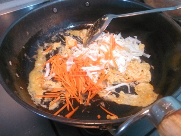 放入紅蘿蔔絲與高麗菜絲拌炒約2分鐘。