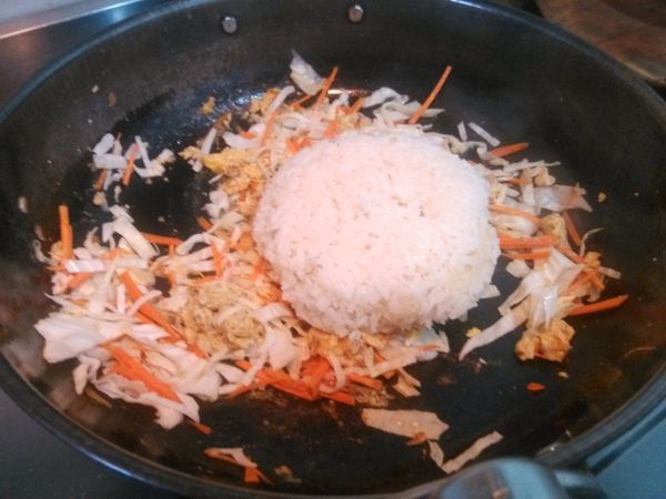 然後放入白飯，並且加入少許的鹽與白胡椒粉，翻炒均勻。