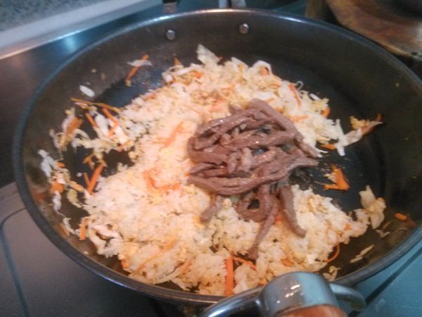 翻炒至白飯熱了之後，加入先前先炒過的牛肉絲。繼續翻炒約3分鐘後，灑上蔥花再翻炒幾下就可以起鍋盛盤上桌。