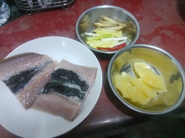 將魚片洗淨擦乾表面水分(若是使用全魚，魚身兩面記得用刀子斜劃2~3刀)，抹上薄薄的一層鹽；生薑切絲，蔥白切成蔥段，蔥綠部分切絲；紅辣椒切片；鳳梨切小片(若是使用新鮮鳳梨，鳳梨心的部分要切除)。