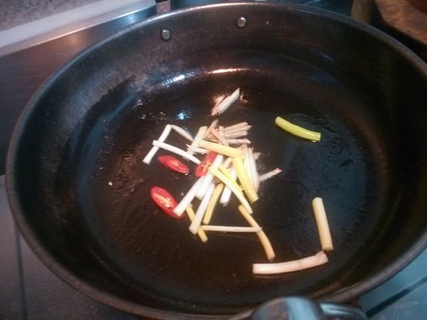 原鍋原油放入薑絲、辣椒片與蔥段爆香。