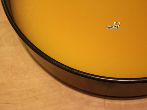 [柳橙布丁層] 鮮橙汁與布丁粉微微加溫煮開做成柳橙果凍，稍稍降溫在液態下緩慢倒在海綿蛋糕上！蛋糕邊緣鋪上烤紙的原因是"防漏"，以免布丁尚未結凍時從底部滴出。這個步驟完成後放在冰箱冷藏四十分鐘左右直到布丁結凍。可用吉利丁太替布丁粉步驟類似，但別忘了吉利丁與橙汁的比例要換算唷。