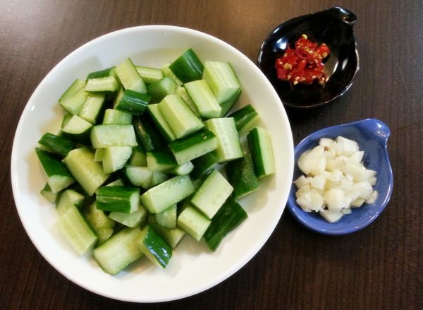 小黃瓜洗淨，去頭尾，切成條狀，蒜頭拍碎或切片，辣椒切片；