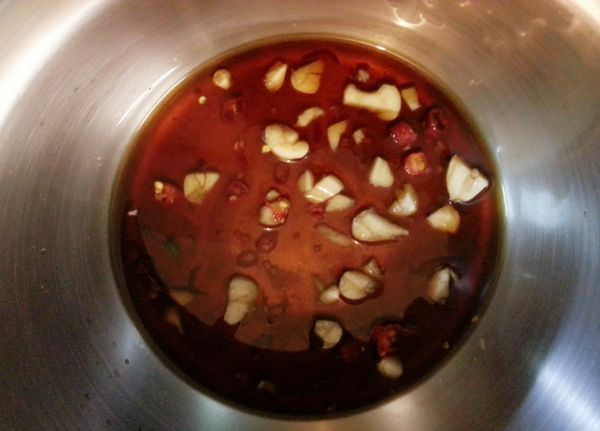 準備鋼盆，倒入少許醬油、白砂糖和梅子醋，再加入已切好的蒜片、辣椒片，最後倒入川燙好的小黃瓜，用筷子攪拌均勻；