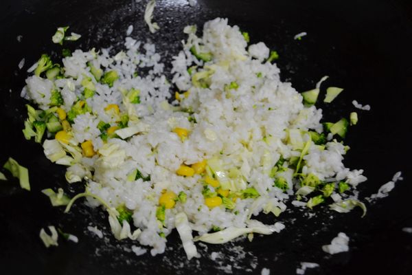 加入高麗菜絲、花椰菜、玉米粒、小黃瓜翻炒。