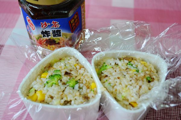 取三角模型，鋪上保鮮膜再填入壓緊炒好的飯。