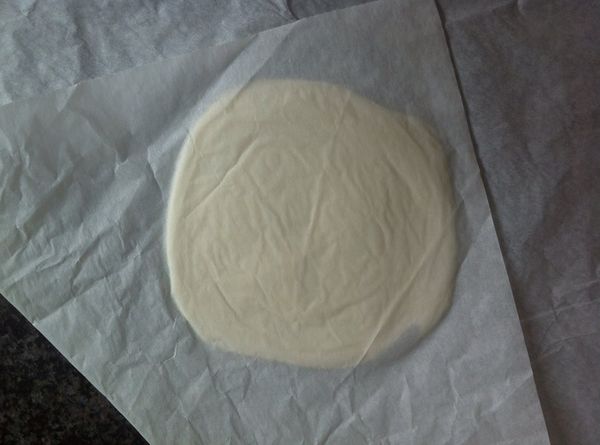 利用烘焙紙蓋住塔皮，用擀麵棍輕輕的擀成直徑約10公分寬的圓型。