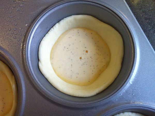 將準備好的布丁液倒入塔皮裡，只要倒5分滿即可，酥皮會長高，倒太多布丁液會液出來。