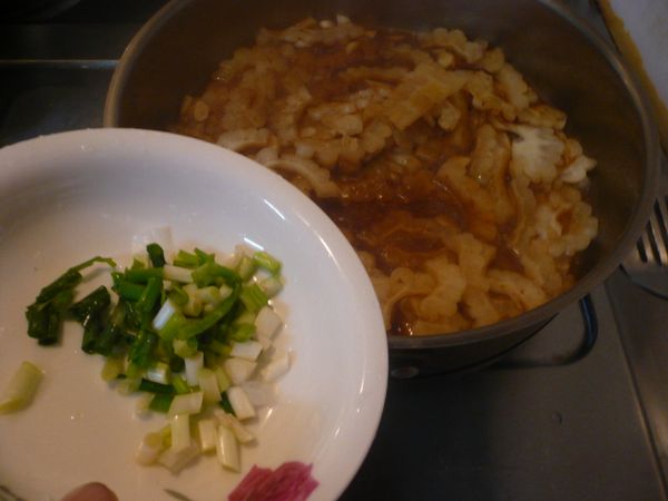 打開鍋蓋翻炒一下，讓未熟的苦瓜繼續加熱，放入青蔥洗淨切成末拌炒一下，即可熄火上桌。