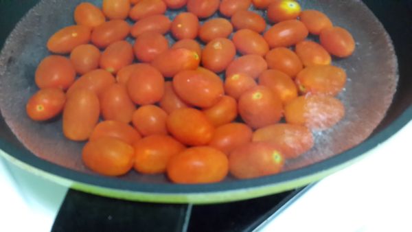 小番茄洗淨.去蒂頭.在蒂頭這端上面用刀子輕畫十字.燒一鍋滾水.水滾後將小番茄下鍋.煮30秒後關火.停留30秒即可撈起.泡入冰涼的冷開水裡