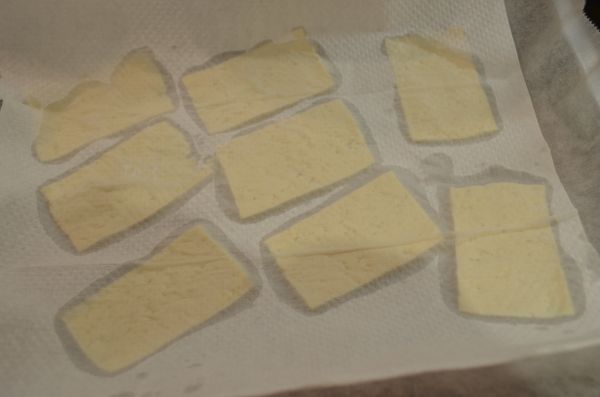 將豆腐切成薄片（約 0.3 - 0.4 mm 厚）放在廚房紙巾上，再用些許紙巾仔細吸去水分，水分越少製作出來的豆腐片就會越脆。