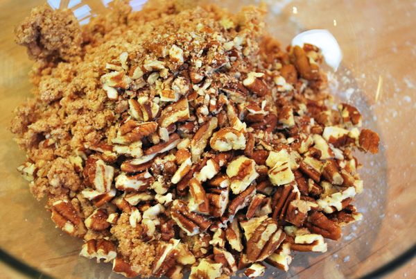 取一小盆混合肉桂酥頂的材料，用手指撥碎成小米粒狀，加入烘烤過的胡桃碎粒，拌勻備用
