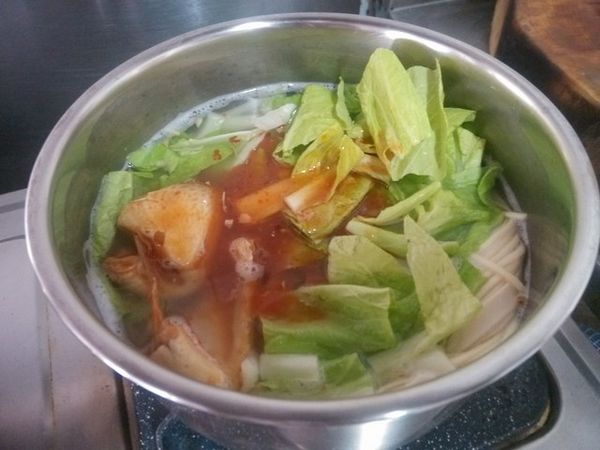 當麵條呈半熟狀態，將青菜放入，茄汁鯖魚罐頭打開，連湯汁都倒入，並用湯瓢拌均勻。