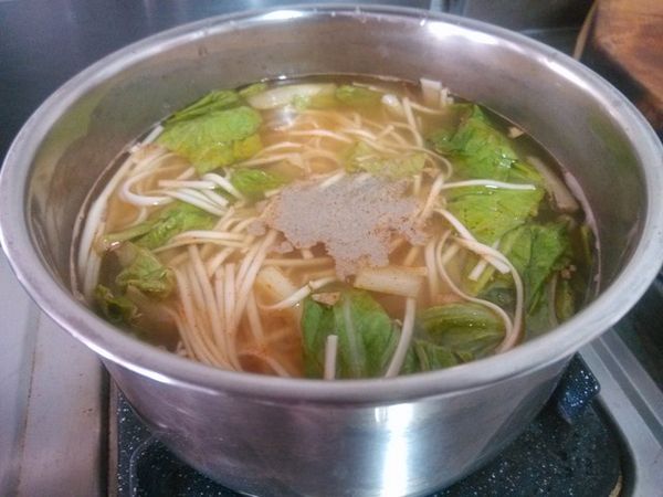 當麵條已經熟了時，加入適量的鹽與少許的白胡椒粉調味，攪拌均勻後，將蛋汁以繞圈方式倒入。