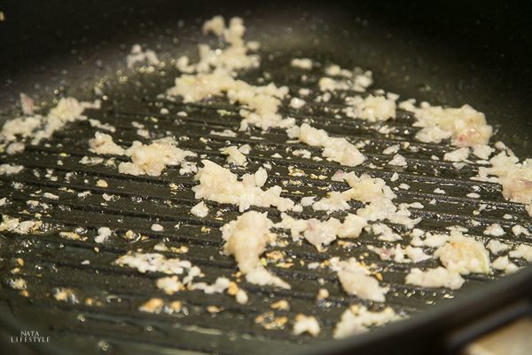 轉小火以鍋內餘油炒香蒜末、紅蔥頭末，等香氣傳出後，放入備用的豬皮與五花肉丁拌炒勻和。