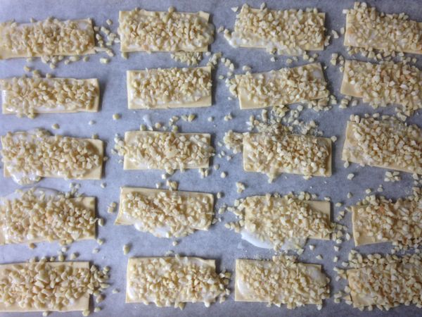 起酥片鋪在烤紙上，上頭先擠上適量的蛋白糖醬後再均勻的灑上杏仁角粒後進預熱好的烤箱攝氏180度烤約15分鐘即可。