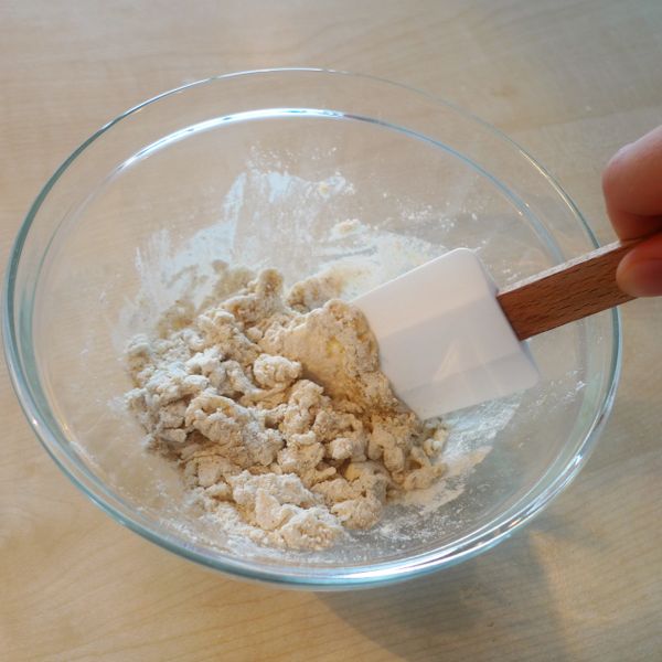 水批次且慢慢地加入盆中，攪拌均勻至稍微成團即可。