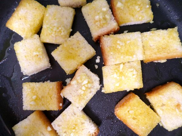 平底鍋中放入2大匙橄欖油中火加熱, 放入麵包丁煎至金黃取出