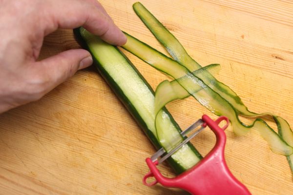 用削皮刀把小黃瓜削成薄片。