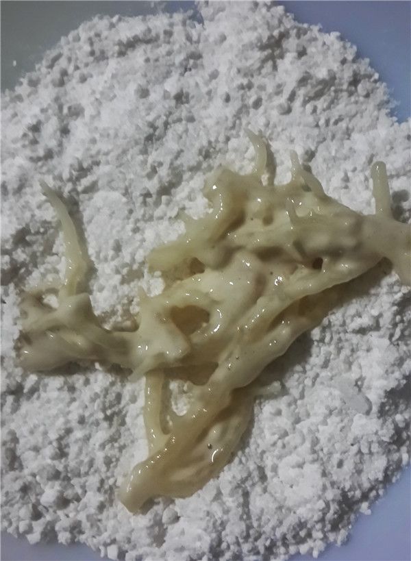 再過篩地瓜粉，將沾裹麵糊的珊瑚草沾裹地瓜粉