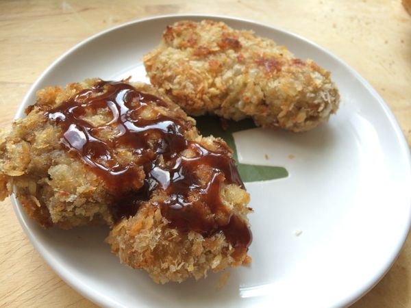 在豬排上淋上日式豬排醬，放入土司中。