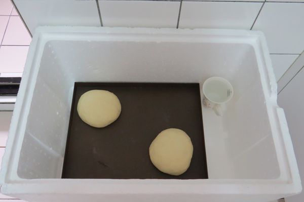 分切割成2個450g的麵團，將麵團揉成表面光滑的圓狀即可，並再放入保麗龍箱內加杯熱水，進行中程發酵，時間30分鐘
