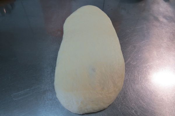 再用桿麵棍桿把麵團往前推平，然後再翻面