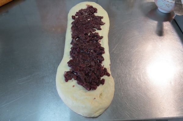 將紅豆餡平均的擺上麵團上