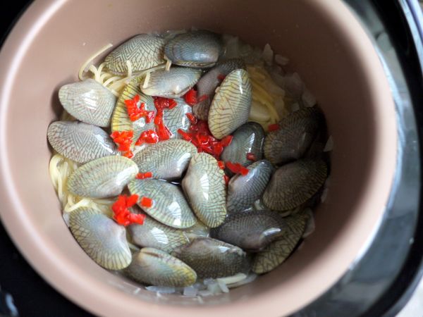 待顯示分鐘數剩7分鐘後開蓋，加入海瓜子、白酒、辣椒碎、橄欖油，再蓋上加熱