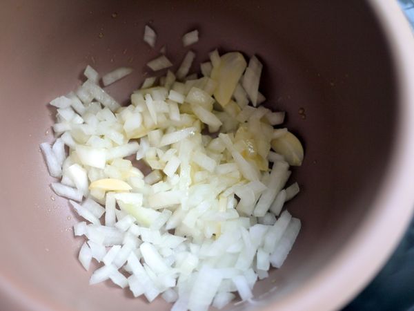 加熱約４分，在鍋中加入橄欖油，放入蒜片、洋蔥末拌炒至半透明