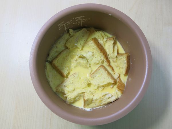 土司撕成小塊，放入蛋奶液中混合吸飽汁液，將內鍋放進飛利浦微電鍋裡。