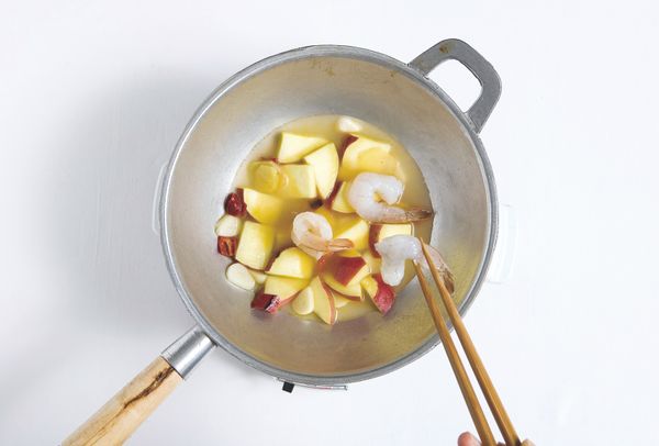 將油倒進底部是圓形的平底鍋中，炒過大蒜和生薑後，加入2的煮蝦頭的水、地瓜、乾辣椒一起煮，地瓜煮熟後，再加入蝦子。