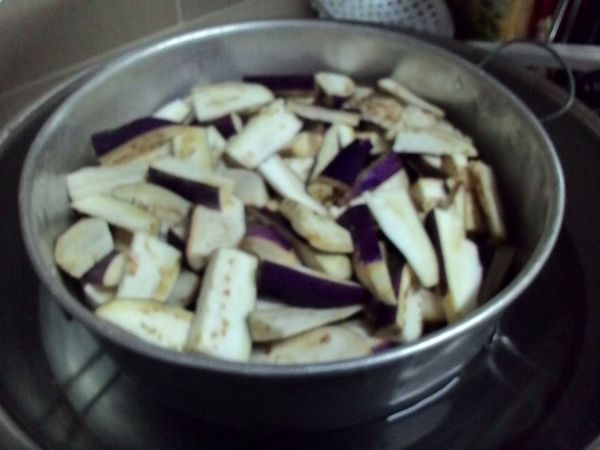 把茄子切成适当的块状。放半茶 匙食油在蒸盘里抹均。放入蒸笼里蒸。