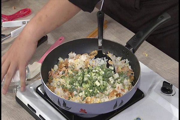加入蔥花拌炒至香氣滲入飯中