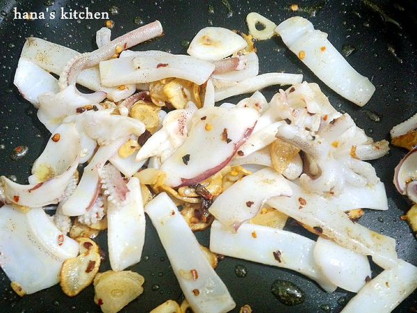 義大利麵快煮熟前三分鐘,鍋子加熱後,倒入少許橄欖油,用小火將蒜片煎到成金黃色後和辣椒,烏賊一起放入拌炒,

這時先加少許胡椒粉,這樣烏賊比較入味