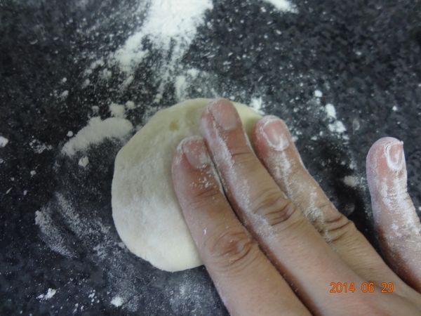 10工作桌上撒手粉取一個圓麵糰先用手壓平
