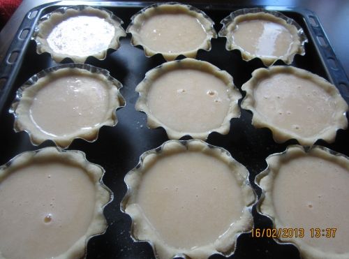 將蛋塔水倒入模具中，如圖約9分滿即可。烤箱先預熱10分鐘，將烤盤放入烤箱，180度，中下層，烤25到30分鐘。鸡蛋大小不同，最好只倒9分满，否则会溢出不好脱模，剩下的蛋挞水加些面粉可以煎鸡蛋饼。