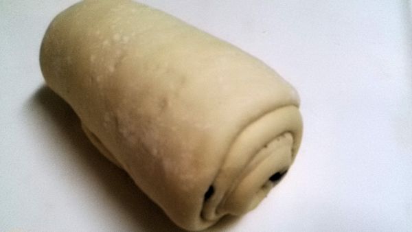 長麵糰由長邊捲起後滾成圓柱狀。