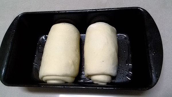 將兩個圓柱狀麵糰平均放於吐司模內。(吐司模先塗薄油以免沾黏)