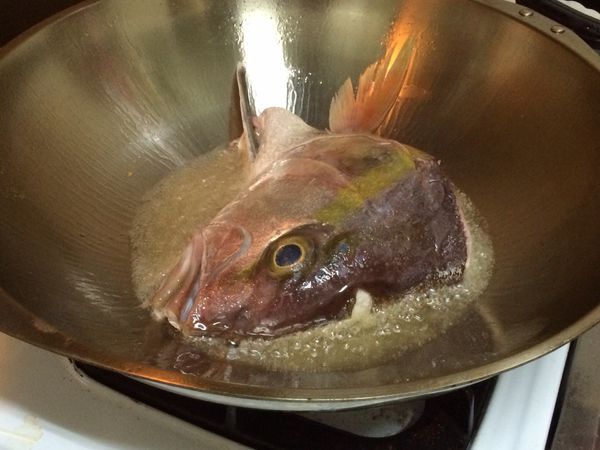 起油鍋將魚頭兩面煎至焦香
